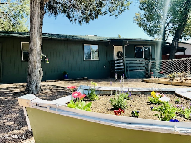single story home featuring a vegetable garden and fence