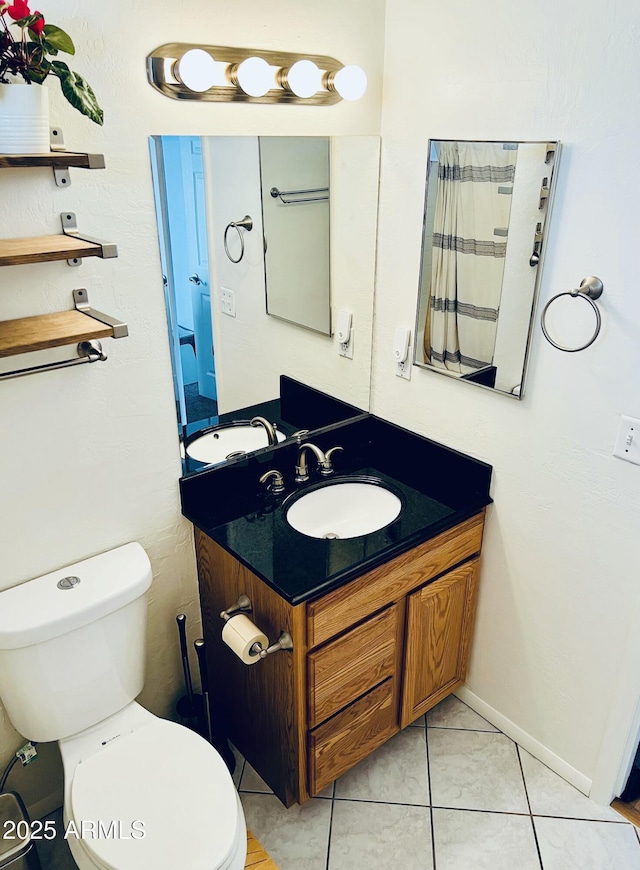 bathroom with tile patterned flooring, vanity, and toilet