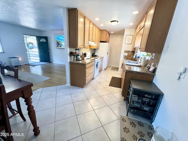 kitchen featuring white appliances, under cabinet range hood, recessed lighting, decorative backsplash, and light tile patterned flooring