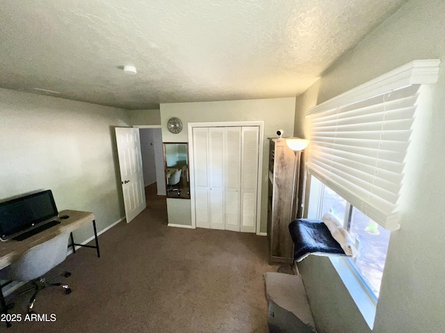 unfurnished office with baseboards, a textured ceiling, and carpet floors