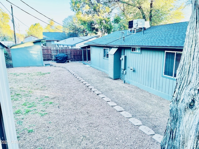 view of yard with a patio area, fence, an outbuilding, and a storage unit