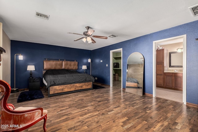 50031 N 27th Ave, New River, AZ 85087 - bedroom featuring wood finished floors, baseboards, a sink, a textured wall, and ensuite bathroom