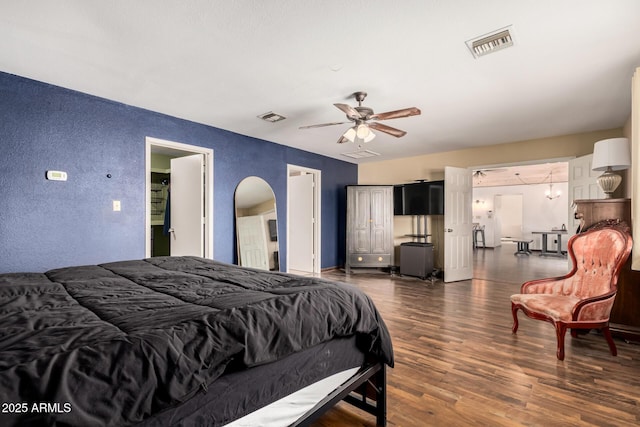 50031 N 27th Ave, New River, AZ 85087 - bedroom featuring a textured wall, wood finished floors, ceiling fan, and arched walkways