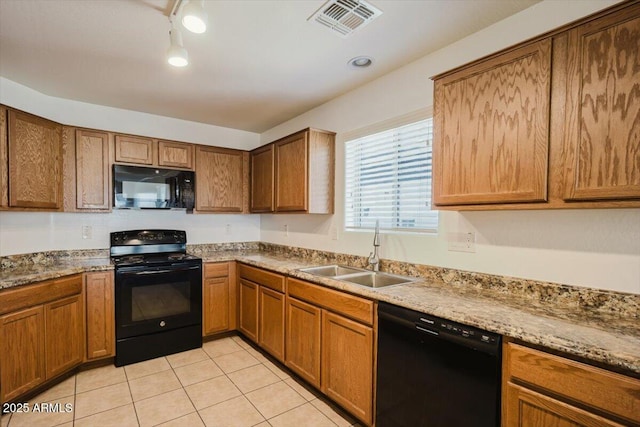 kitchen with light tile patterned floors, brown cabinetry, visible vents, black appliances, and a sink