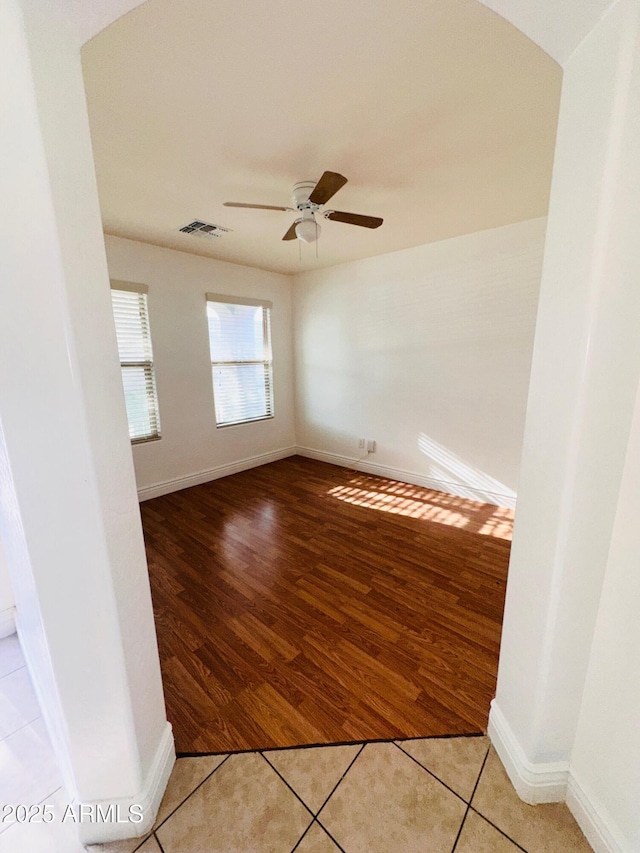 spare room with visible vents, ceiling fan, light tile patterned flooring, and baseboards