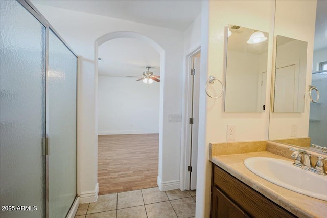 bathroom with vanity, baseboards, tile patterned floors, a shower stall, and ceiling fan