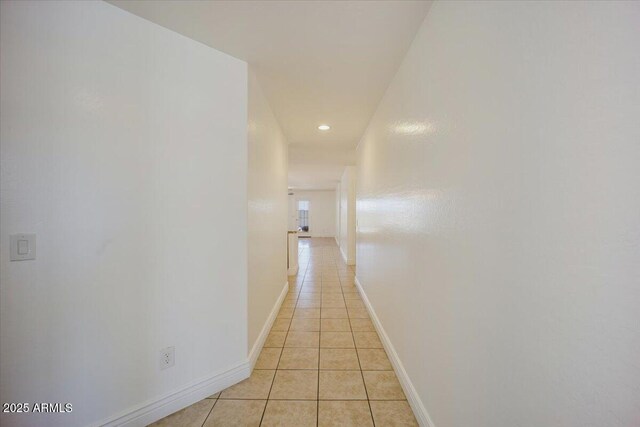 corridor with light tile patterned floors, baseboards, and recessed lighting