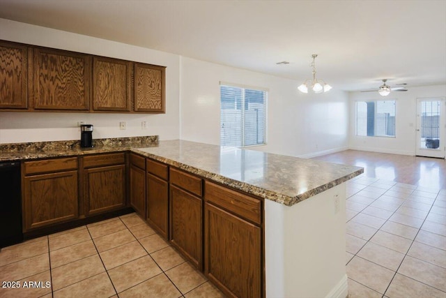 kitchen featuring a peninsula, dishwasher, dark stone counters, and light tile patterned flooring
