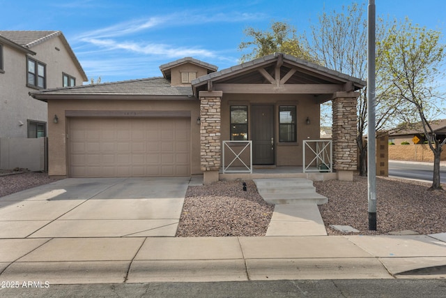 view of front of home featuring an attached garage, covered porch, concrete driveway, a tiled roof, and stucco siding