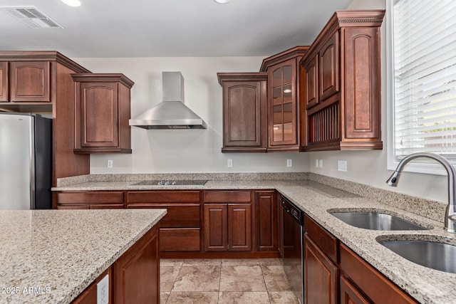 kitchen with visible vents, glass insert cabinets, wall chimney range hood, black appliances, and a sink