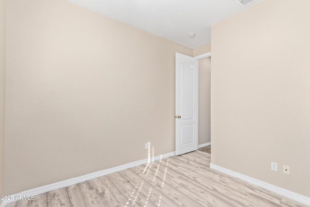 spare room with light wood-style floors, visible vents, and baseboards