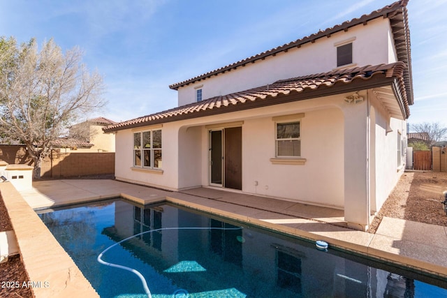 rear view of house featuring a fenced in pool, a patio, stucco siding, a fenced backyard, and a tiled roof