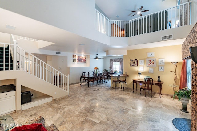 living room with a high ceiling and ceiling fan