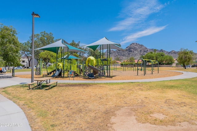 view of jungle gym featuring a mountain view and a yard