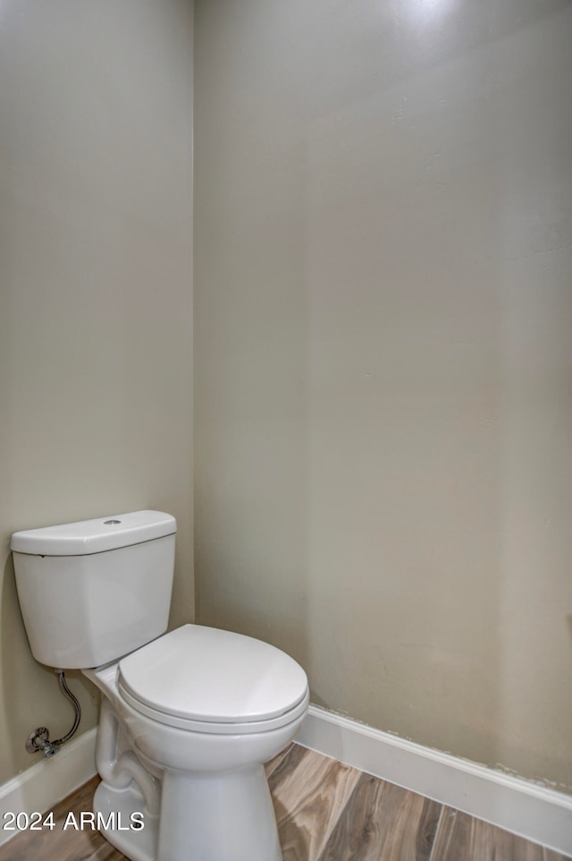 bathroom with toilet and wood-type flooring