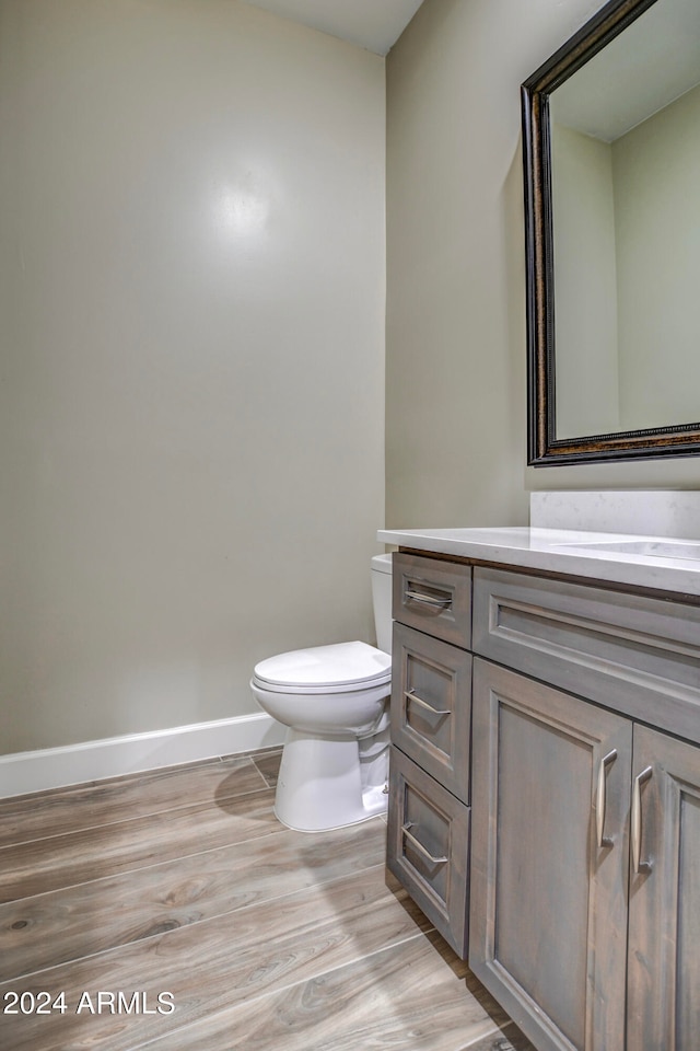 bathroom featuring hardwood / wood-style floors, toilet, and vanity