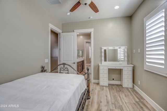 bedroom with ceiling fan, ensuite bath, and light wood-type flooring