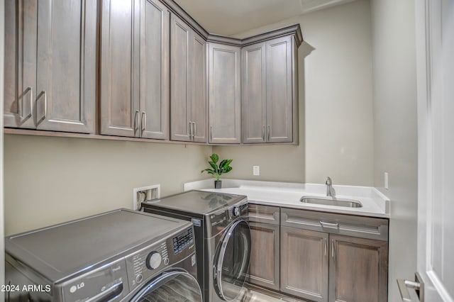 laundry room featuring independent washer and dryer, sink, and cabinets