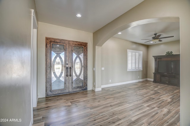 foyer with ceiling fan, french doors, and light wood-type flooring