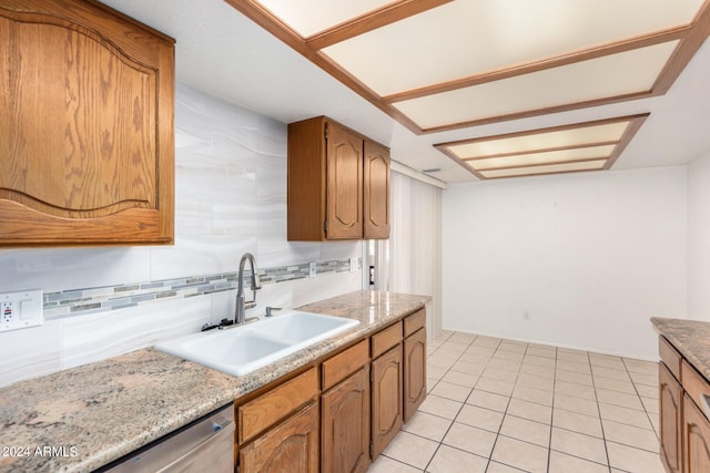 kitchen with decorative backsplash, stainless steel dishwasher, light tile patterned floors, and sink