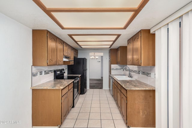 kitchen featuring a textured ceiling, sink, decorative backsplash, black appliances, and light tile patterned floors