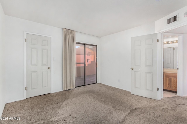 unfurnished bedroom featuring ensuite bathroom, visible vents, carpet floors, and access to exterior