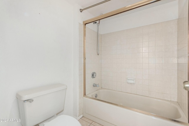 bathroom featuring tile patterned floors, tiled shower / bath, and toilet