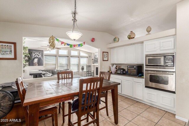 tiled dining area with vaulted ceiling and ceiling fan