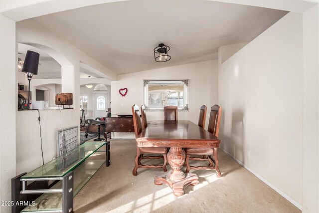 dining space with lofted ceiling, plenty of natural light, and carpet