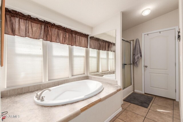 bathroom featuring independent shower and bath, vaulted ceiling, and tile patterned flooring