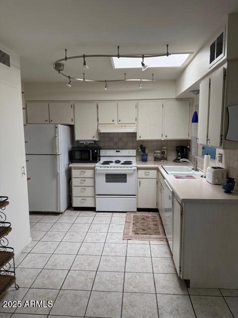 13822 N Silverbell Dr Unit 15C, Sun City, AZ 85351 - kitchen featuring white appliances, under cabinet range hood, a sink, backsplash, and light countertops