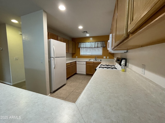 kitchen with white appliances, sink, and light tile patterned floors