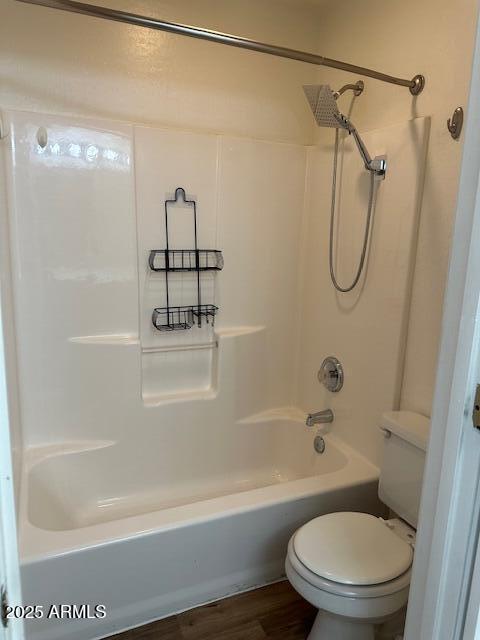 bathroom with shower / tub combination, wood-type flooring, and toilet