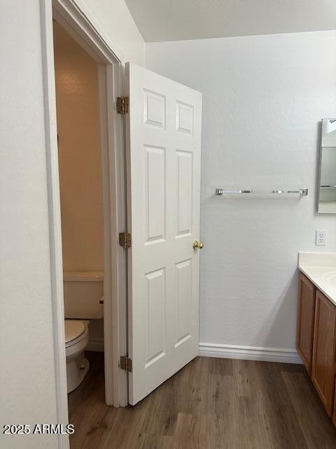 bathroom with vanity, hardwood / wood-style floors, and toilet