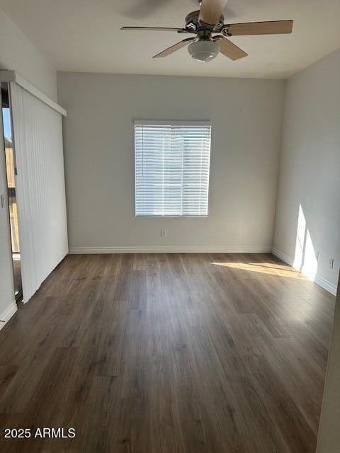 spare room featuring dark hardwood / wood-style flooring and ceiling fan