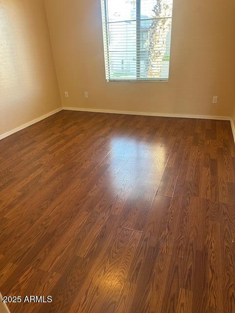 unfurnished room with dark wood-type flooring