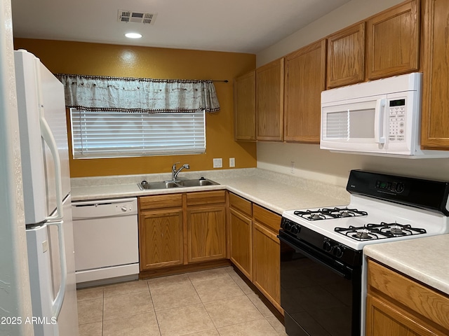 kitchen with white appliances, sink, and light tile patterned floors