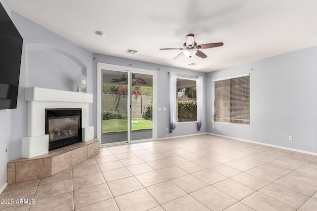 9142 W Pontiac Dr, Peoria, AZ 85382 - unfurnished living room featuring a tiled fireplace, a ceiling fan, and light tile patterned floors