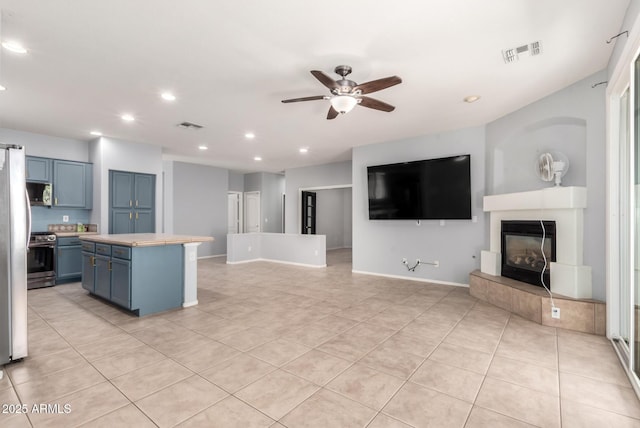 9142 W Pontiac Dr, Peoria, AZ 85382 - kitchen with blue cabinets, light countertops, recessed lighting, a ceiling fan, and light tile patterned floors