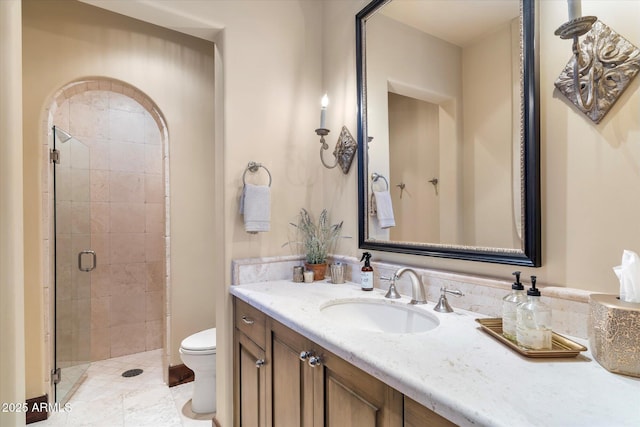 full bathroom featuring a stall shower, vanity, and toilet