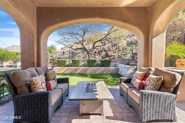 view of patio with an outdoor living space with a fire pit and fence