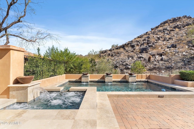 view of swimming pool featuring fence, a fenced in pool, and an in ground hot tub