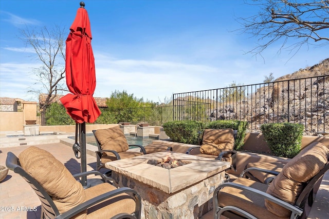 view of patio / terrace with an outdoor fire pit and fence