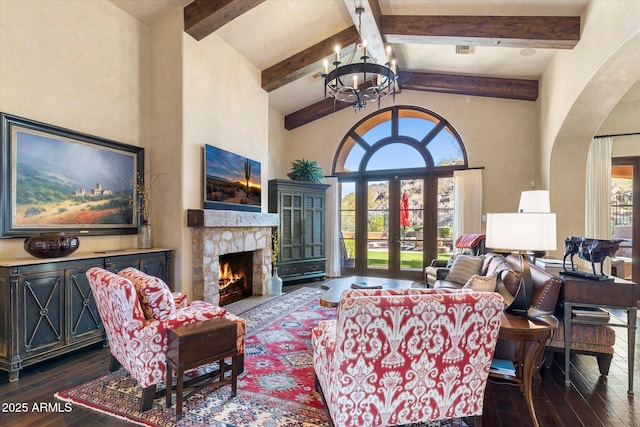 living room with high vaulted ceiling, a fireplace, dark wood finished floors, and an inviting chandelier