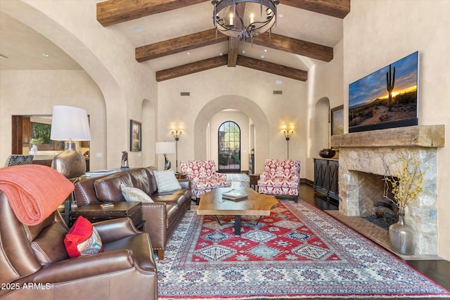 living room with high vaulted ceiling, a fireplace, beamed ceiling, and wood finished floors