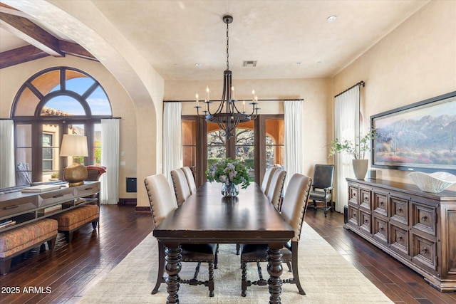 dining room with dark wood-type flooring, arched walkways, visible vents, and a notable chandelier