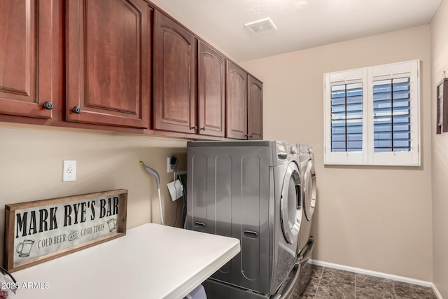 laundry room featuring cabinets, independent washer and dryer, and dark tile patterned flooring