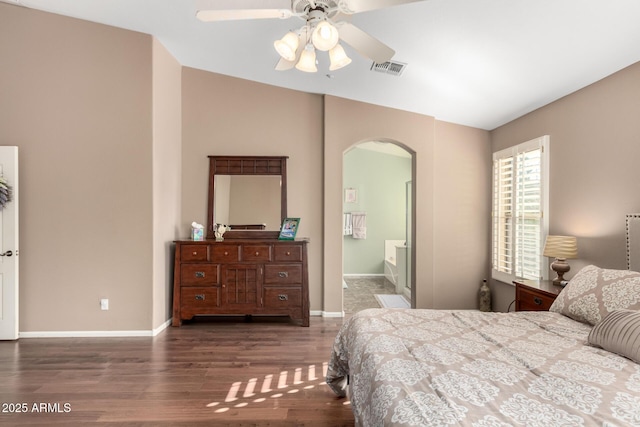 bedroom with dark hardwood / wood-style flooring, ensuite bath, and ceiling fan