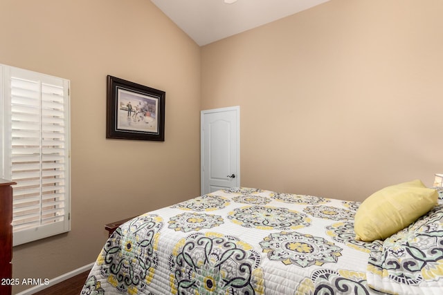 bedroom with hardwood / wood-style floors and lofted ceiling