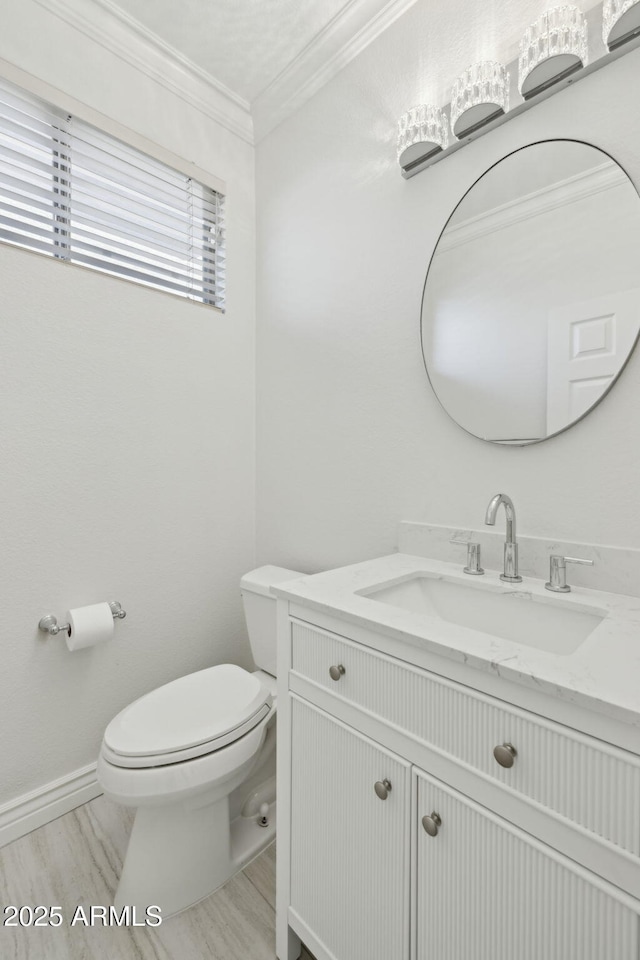 bathroom featuring crown molding, vanity, and toilet